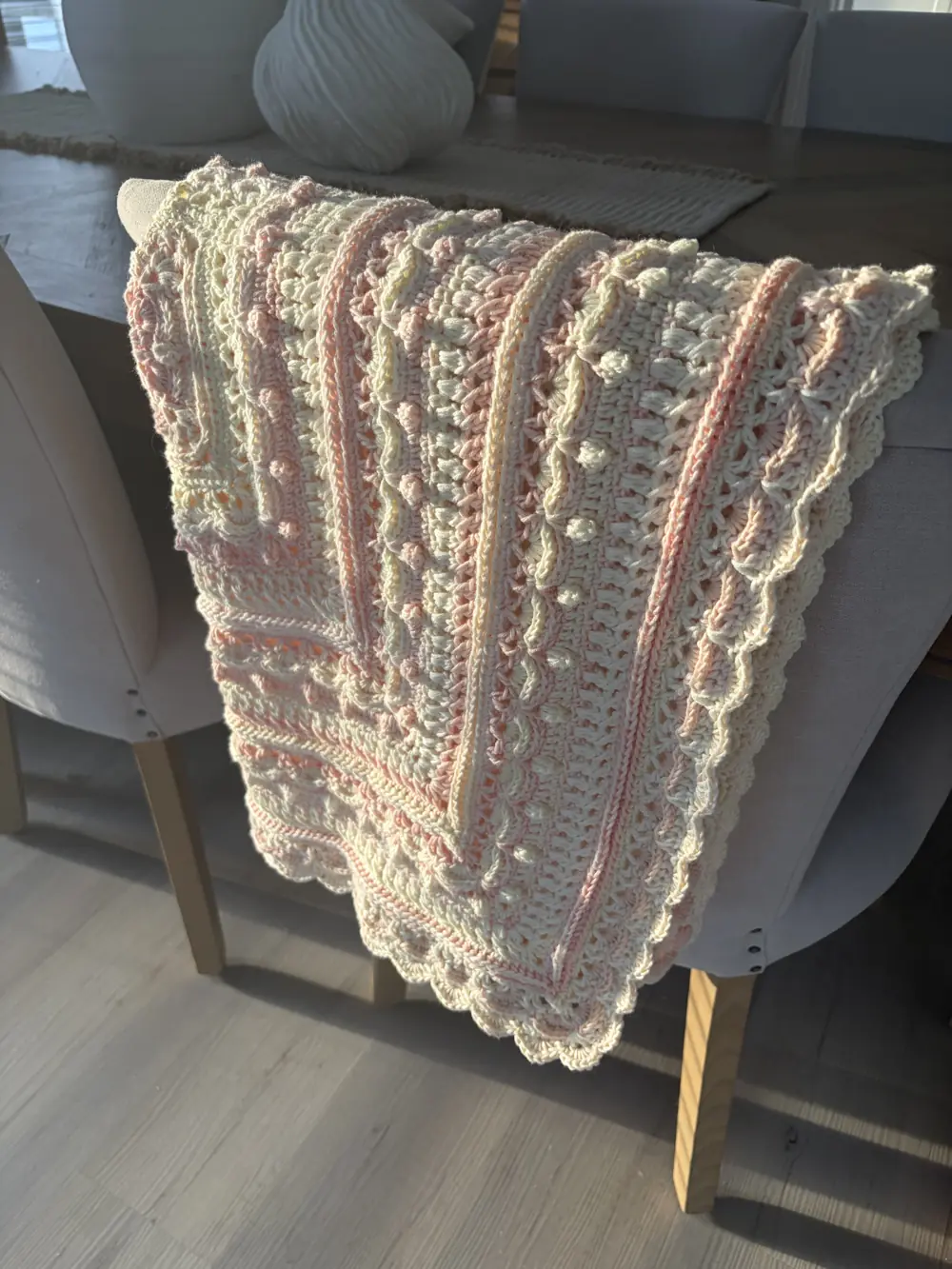 Cream and pink crocheted blanket with a scalloped edge